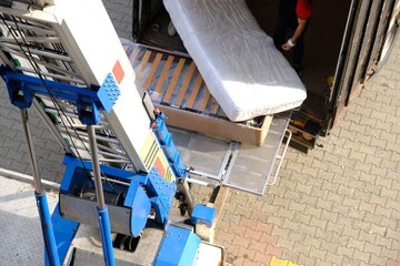 House moving with elevators. Lifting beds, paintings, refrigerators, coffee tables, and other packaged items. Movers loading items onto trucks. Tenants, homeowners. House rents. Housing prices. © arzu