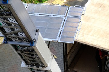 Obraz premium House moving with elevators. Lifting beds, paintings, refrigerators, coffee tables, and other packaged items. Movers loading items onto trucks. Tenants, homeowners. House rents. Housing prices.