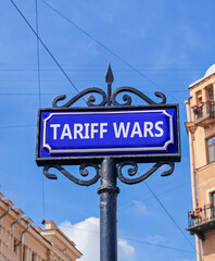 Obraz premium Trade tariff wars symbol. Concept word Tariff wars on beautiful blue road sign. Beautiful blue sky and buildings background. Business trade tariff wars concept. Copy space.