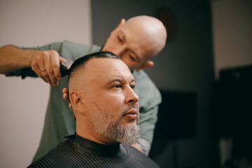 Male haircut at barbershop with caucasian barber and client