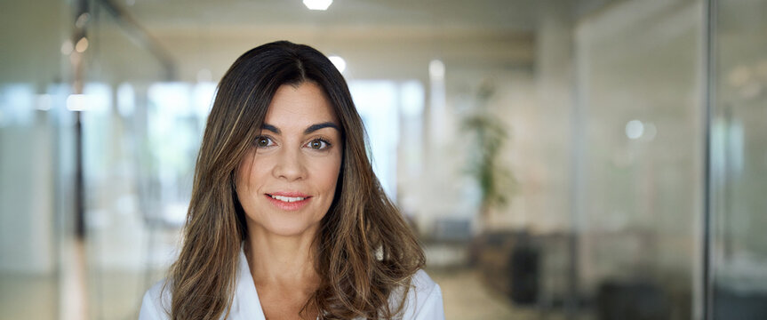 Smiling professional middle aged elegant business woman corporate leader, happy mature female executive, 45 years old lady manager standing in office looking at camera, headshot portrait. Banner