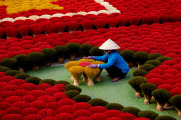 Female worker organizing vibrant incense sticks in vietnamese village