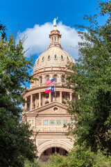 The Texas State Capitol Building with American flags in Austin, Texas, USA.
