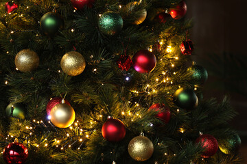 Christmas tree with decorations, fairy lights surrounded by many beautiful colored balls for Christmas and new year celebration.