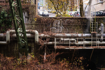 Fernw&auml;rmeleitung vor alten Industriegeb&auml;uden am Ufer der Wupper, Wuppertal, Deutschland