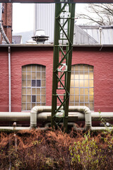 Fernw&auml;rmeleitung vor alten Industriegeb&auml;uden am Ufer der Wupper, Wuppertal, Deutschland