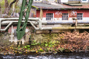 Fernw&auml;rmeleitung vor alten Industriegeb&auml;uden am Ufer der Wupper, Wuppertal, Deutschland