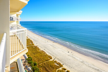 Fototapeta premium High angle balcony view of the sandy beach and dunes along the Grand Strand of the Atlantic Ocean at North Myrtle Beach, South Carolina, on a sunny winter day.