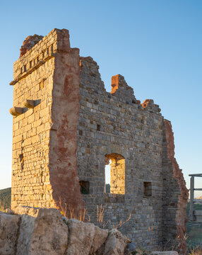 The thousand-year-old remains of the Rocca di Campiglia: the keep, the ancient cistern, and the imposing crenellated walls with mullioned windows of the noble palace. Tuscany, Italy