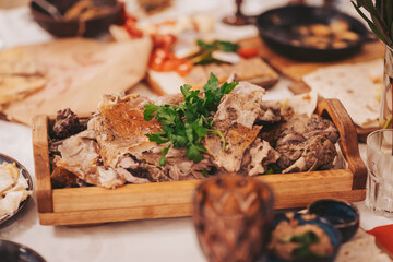 Table with meat dish and various food items during a gathering at a local restaurant in the evening