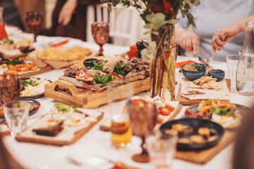 Gathering of friends around a table enjoying various dishes and drinks during a meal in a casual setting in the afternoon