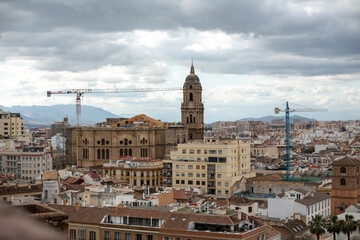 Obraz premium Urban cityscape featuring historical architecture, modern buildings, and construction cranes