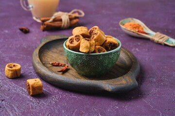 Fototapeta premium Salty Indian cookies bhakar badi with chickpea flour and spices filling in a green ceramic bowl