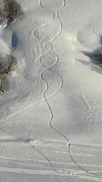 Traces of two snowboards on a pure white mountain slope
