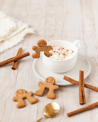 Gingerbread latte with gingerbread man garnish on cup edge and whipped cream