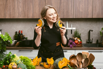 Confident home cook preparing pumpkin with kitchen knife on wooden counter in bright modern kitchen filled with fresh vegetables, creating healthy seasonal meal during autumn cooking session