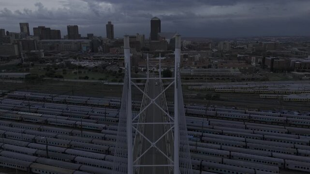 Drone flies south over the Nelson Mandela Bridge on a cloudy afternoon in downtown Johannesburg, South Africa