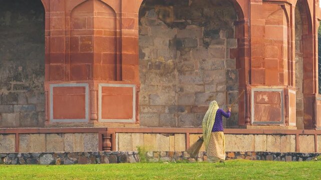 Woman Sweeping Near Purana Qila Wall in Delhi