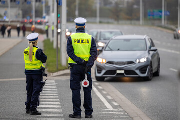 Policjant drog&oacute;wki kieruje ruchem na ulicy.