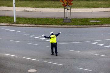 Policjant drogówki kieruje ruchem na ulicy.