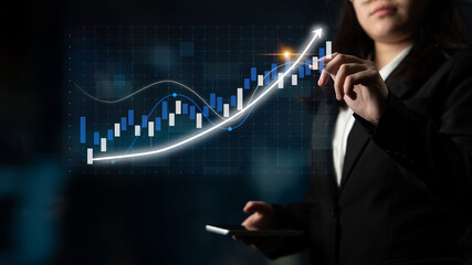 A business professional assesses stock market trends using a modern digital interface. The image emphasizes growth and finance in a corporate environment. Impute