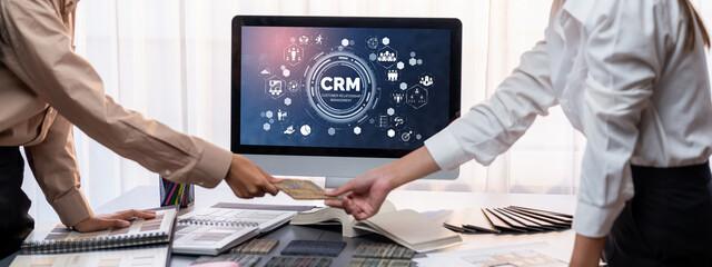 Group of interior architect designer team at table choosing various mood board samples with architecture software on laptop screen. Modern renovation and interior material selection concept. Insight