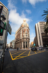 Historic Banco de Valencia building on a busy city intersection, showcasing iconic architecture, urban life, and vibrant Mediterranean atmosphere in downtown Valencia, Spain.