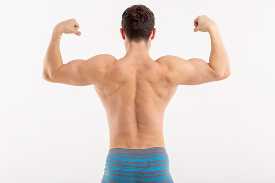 young sports man posing on an isolated background. body parts: inflated relief muscles after exercise. an athlete in his underwear. the guy in the tight pants. men's elastic ass