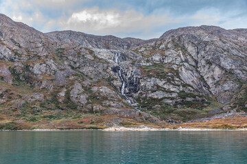 Turquoise Blue Placid Waters of the Labrador Sea fed by a Waterfall and Glacial Silt near the Remote Village of Ivittuut, Greenland in Autumn