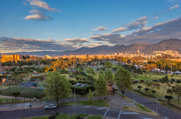 Sunset light over Bogota city park with Andean mountains skyline and dramatic golden evening clouds