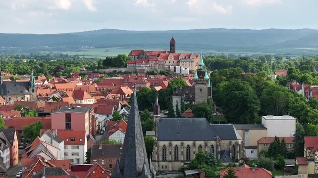 Telephoto drone over Quedlinburg&rsquo;s old town, slow left flight with parallax effect, multiple layers visible, Castle Hill in the center, Harz hills on the horizon, Saxony-Anhalt.