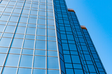 Tall building made mostly glass on a clear sunny day.