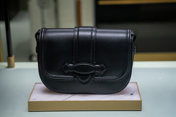 Elegant Black Leather Bag on Display Stand