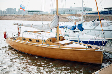 The old wooden sailboat moored in yacht club, calm water in the Gulf of Finland