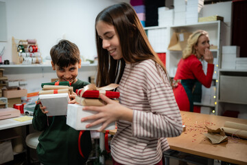 Children receiving christmas surprise gifts from mother