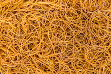 Abstract background texture of thin yellow rubber bands pile