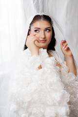 Bridal portrait with floral details in a soft, bright setting during a wedding preparation