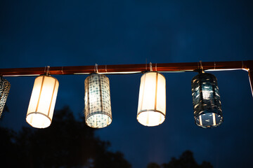 Hanging light bulbs design on a clothesline rope against a red wall like a creative chandelier lamp decoration