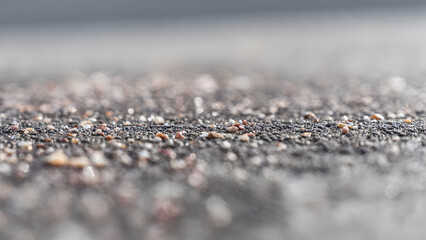 A macro shot of smooth grey pavement with tiny embedded grains forming soft minimal abstract detail