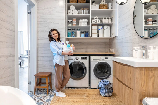Woman housewife posing at modern white wooden bathroom laundry storage minimalism organizing