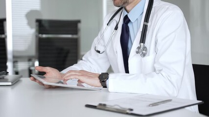 Adult male doctor using digital tablet for remote medical consultation during online telehealth appointment. Medicine, healthcare and science concept - Powered by Adobe