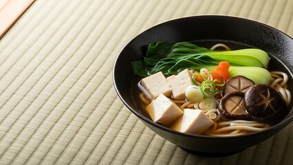 Japanese udon noodle soup with tofu, bok choy and shiitake mushrooms served in black bowl