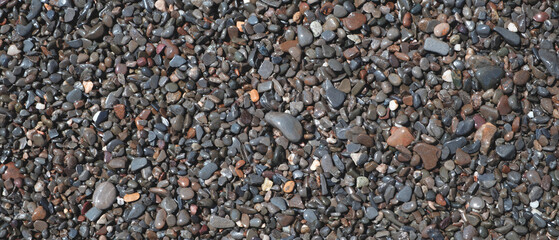 Wet  Pebbles stones on seashore as  texture background for design web banner template page. SPA concept background.