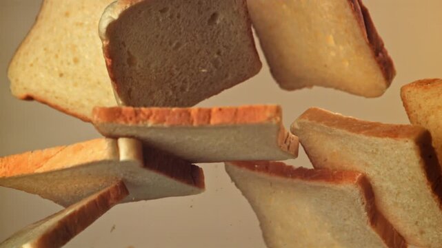 Pieces of bread fly up and fall down against a light background. Filmed on a high-speed camera at 1000 fps. High quality FullHD footage