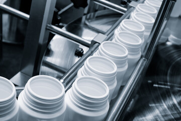 pharmaceutical industry, medicine pills are filling in the  bottle on production line machine conveyor at the medical factory. selective focus.