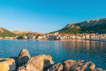 Scenic coastal town with rocky shoreline and historic architecture. Baška, Krk island, Croatia
