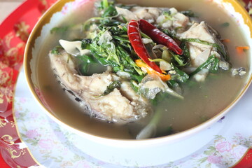 Boiled tilapia in a bowl on wooden table