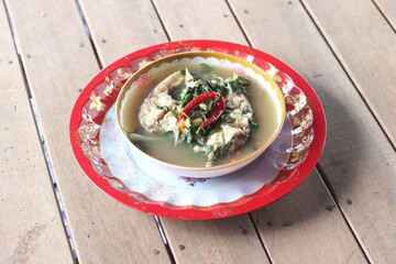 Boiled tilapia in a bowl on wooden table