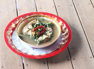 Boiled tilapia in a bowl on wooden table