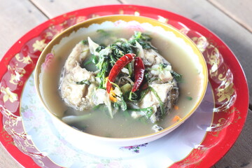 Boiled tilapia in a bowl on wooden table